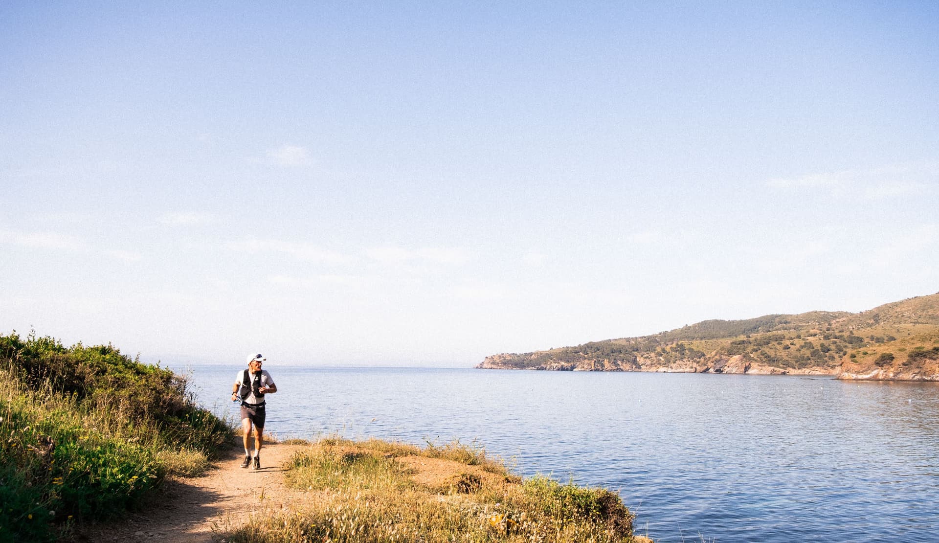 Vista de las calas y crestas rocosas del Cap de Creus durante el Trail Cap de Creus con el faro de fondo